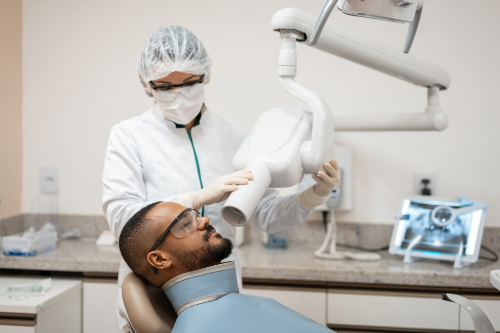 dental assistant taking x-ray of patient's teeth