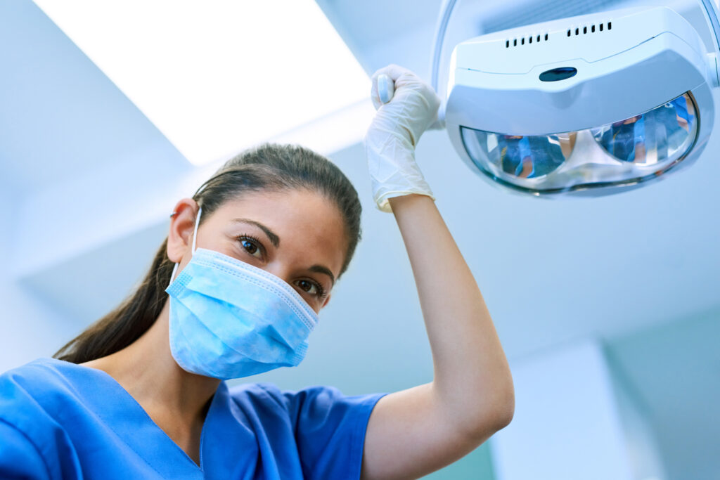 dental assistant holding light facing the camera