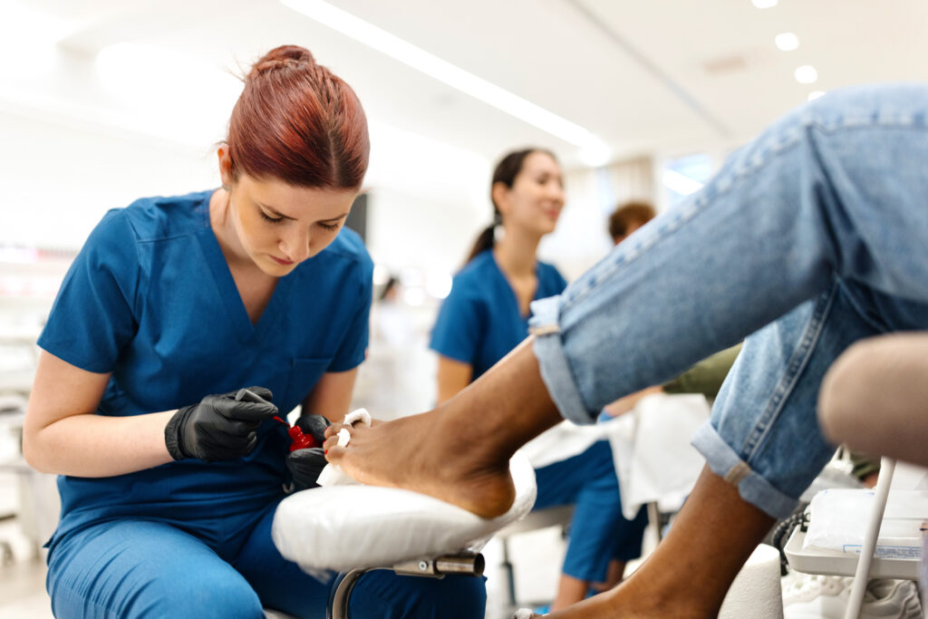 nail technician doing a pedicure on clients feet