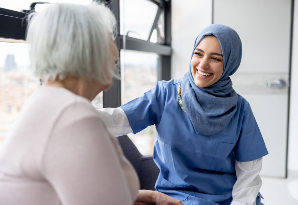 ultrasound technician sitting with patient by window and smiling